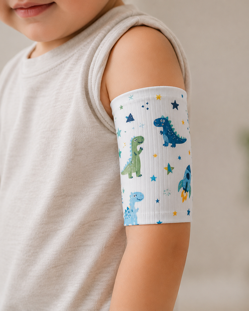 Child's arm with a dinosaur-patterned bandage on a neutral background
